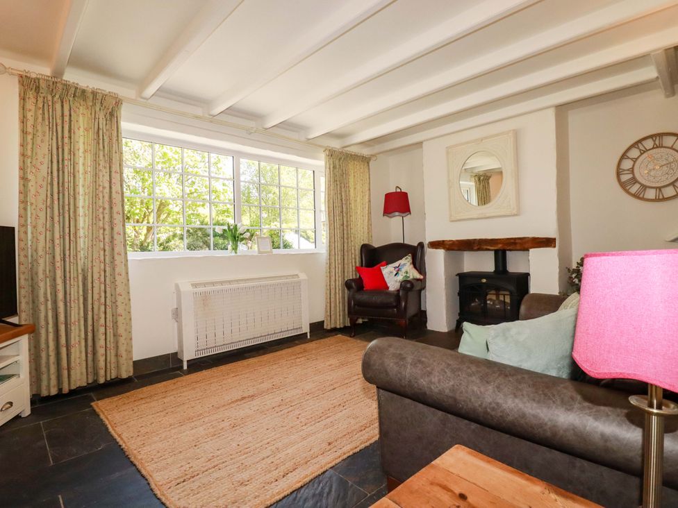 A living room with a window and fireplace at Millies Place in St Austell