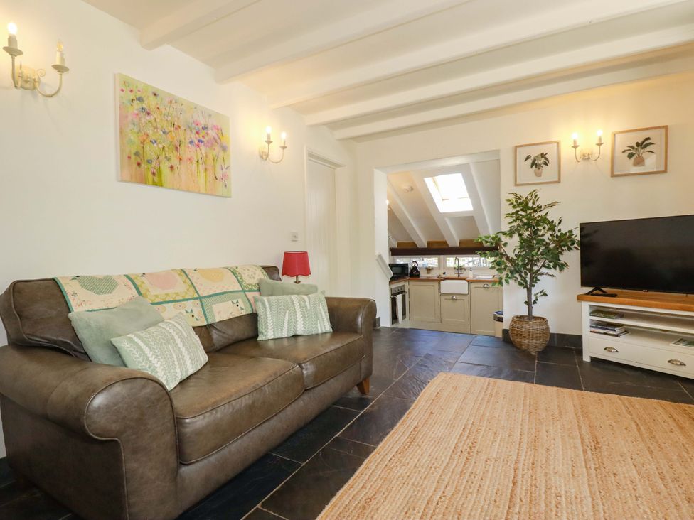 A living room with a sofa and television at Millies Place in St Austell