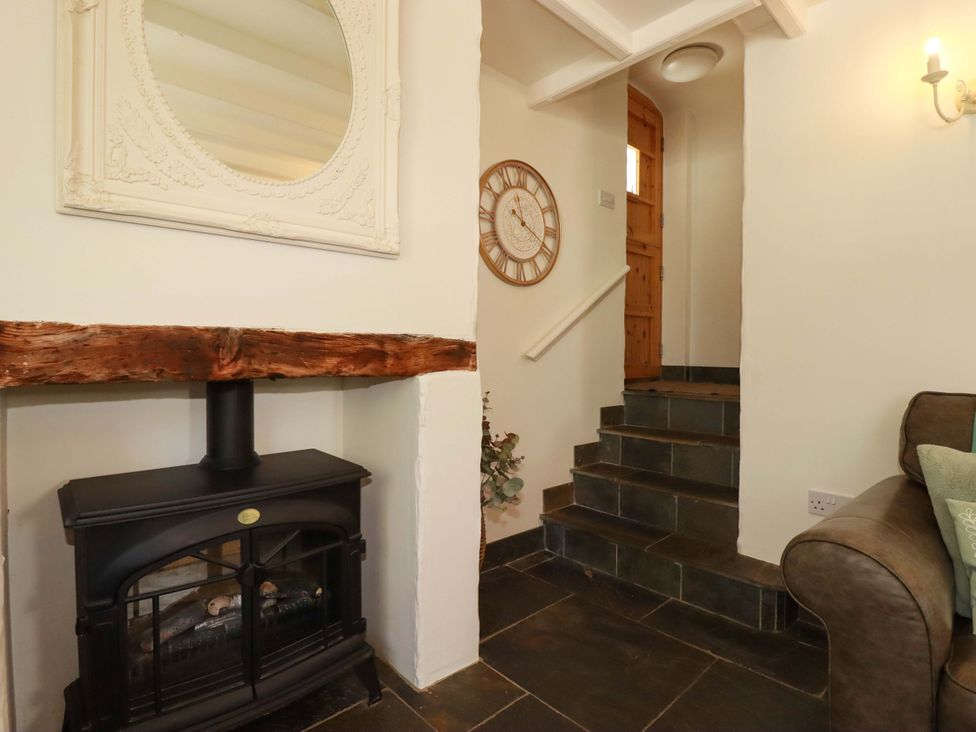 A hallway with a fireplace and stairs at Millies Place St Austell