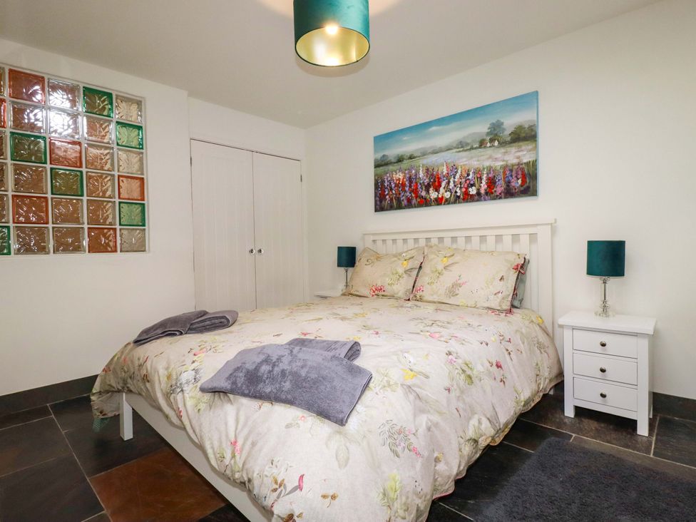 A bedroom with a bed and nightstand at Millies Place St Austell