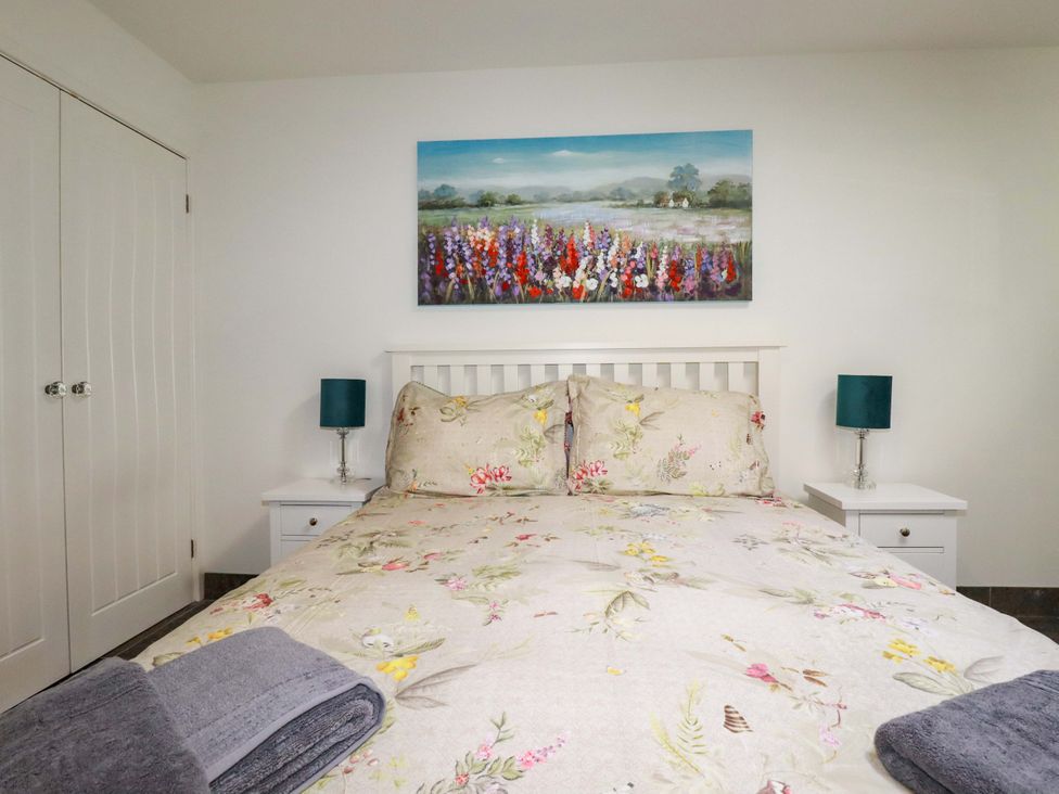 A bedroom with a bed and bedside lamps at Millies Place St Austell
