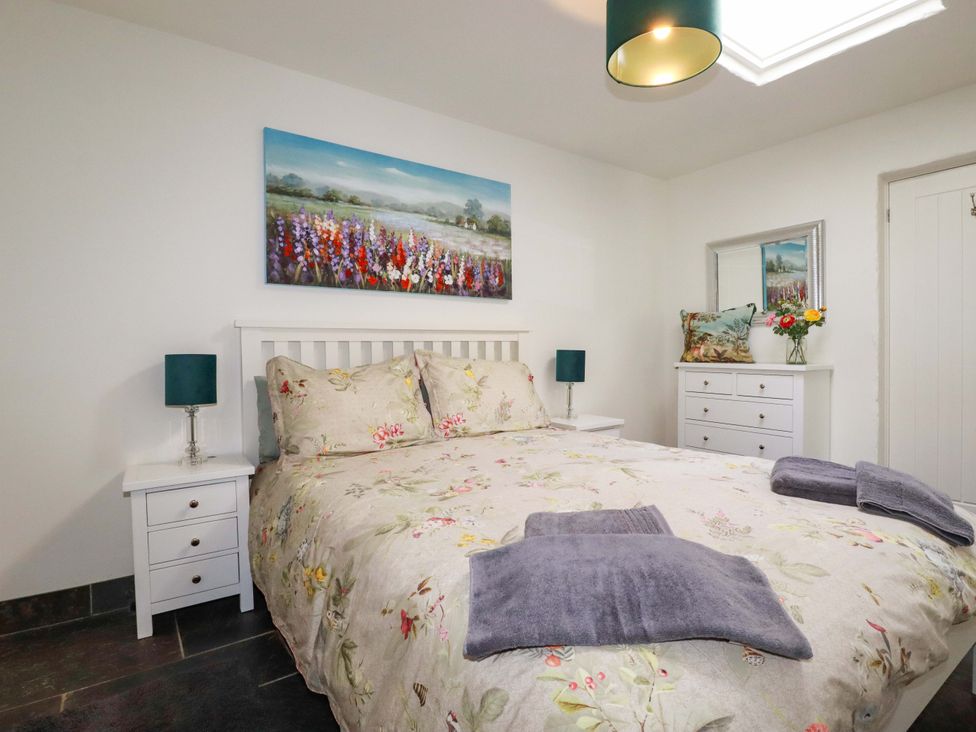 A bedroom with a bed and bedside tables at Millies Place St Austell
