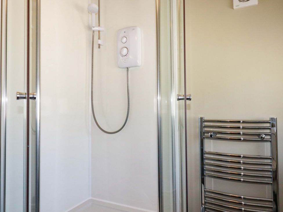 A bathroom with a shower and towel radiator at Millies Place in St Austell
