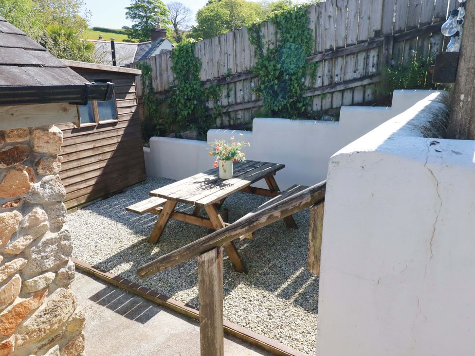 A garden with a picnic table and stone walls at Millies Place in St Austell