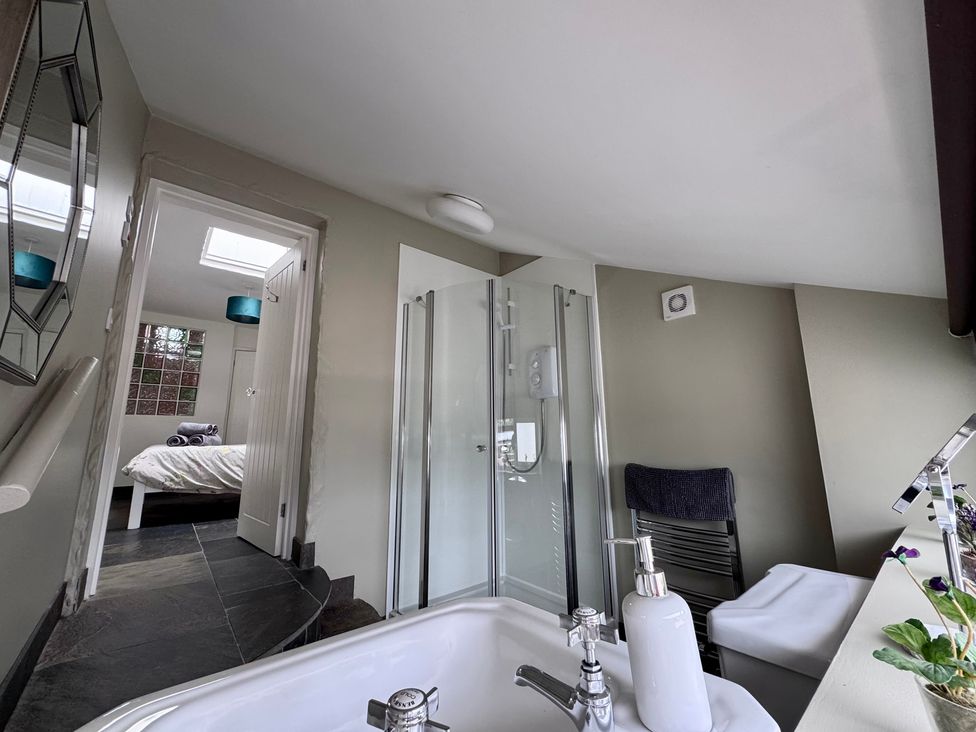 A bathroom with a shower and bathtub at Millies Place in Coombe near Grampound