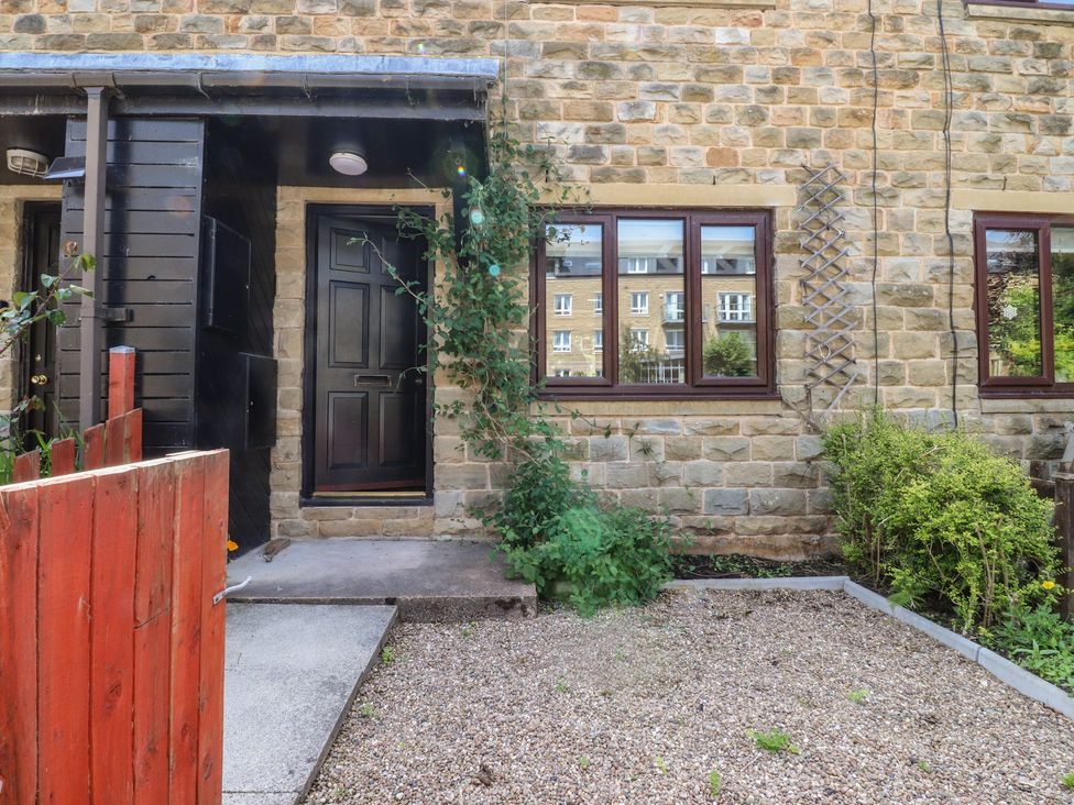 An outdoor entryway with a stone wall and plants at 9 Waterside Fold in Hebden Bridge