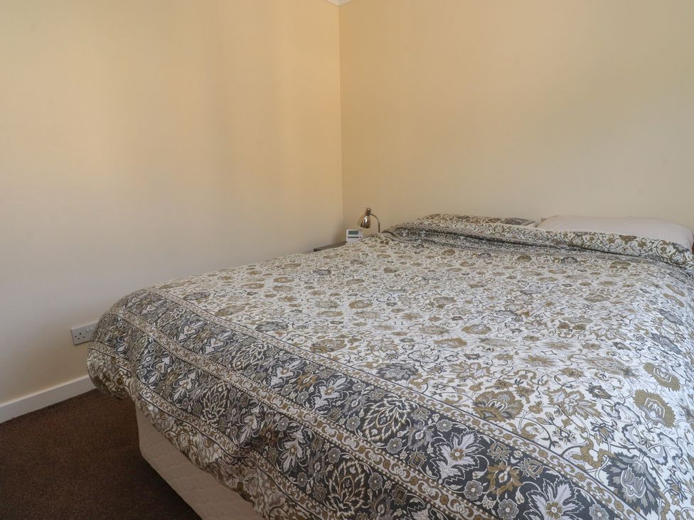 A bedroom with a bed and nightstand at 9 Waterside Fold, Hebden Bridge