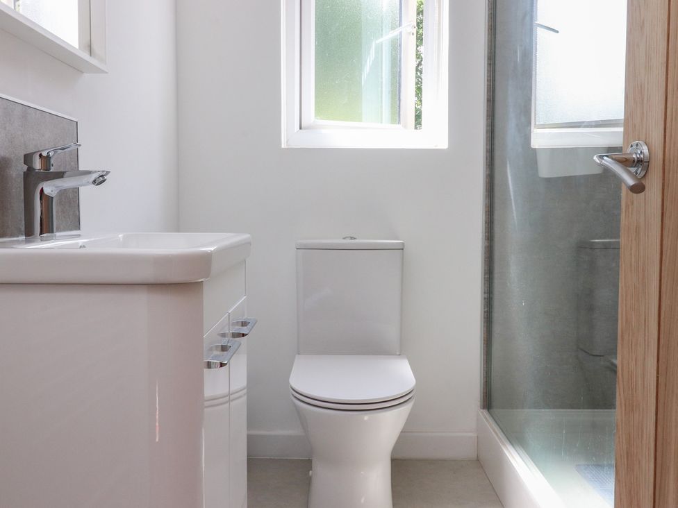 A bathroom with a sink, toilet, and shower at 9 Waterside Fold in Hebden Bridge