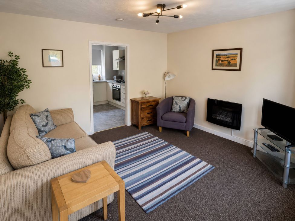 A living room with a sofa and television at Beckside Cottage Hebden Bridge