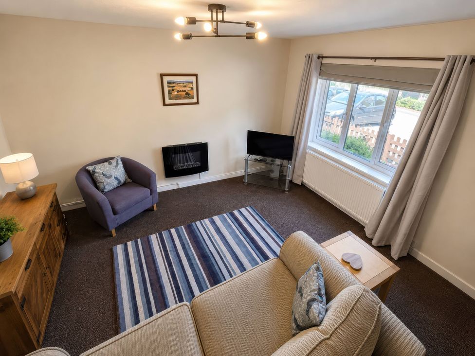 A living room with a sofa and armchair at Beckside Cottage in Hebden Bridge