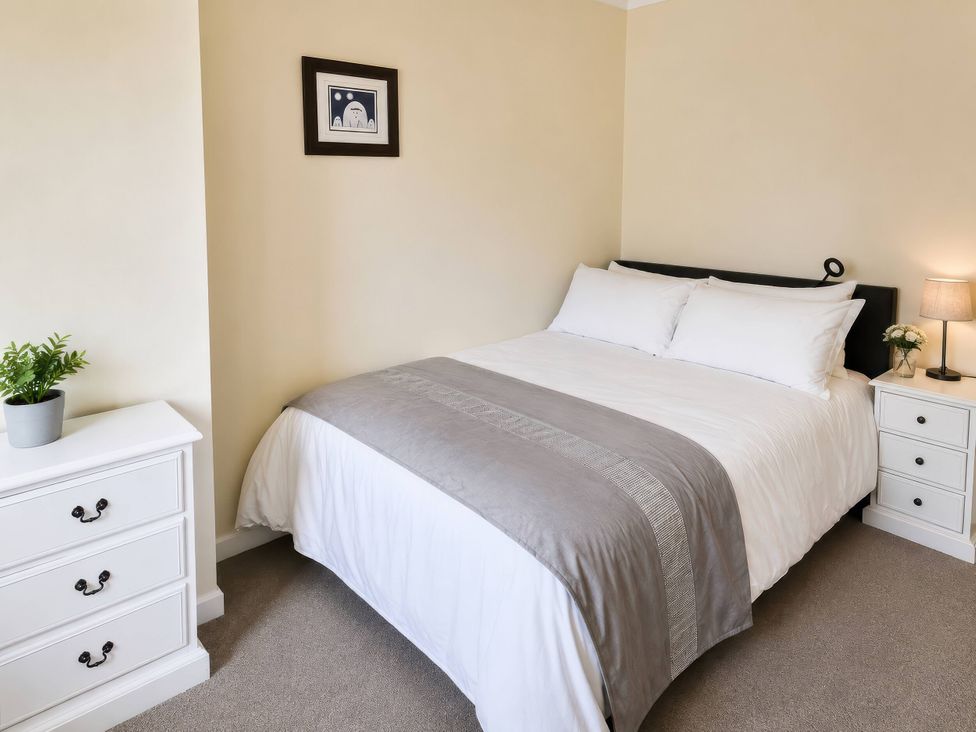 A bedroom with a bed and nightstand at Beckside Cottage in Hebden Bridge