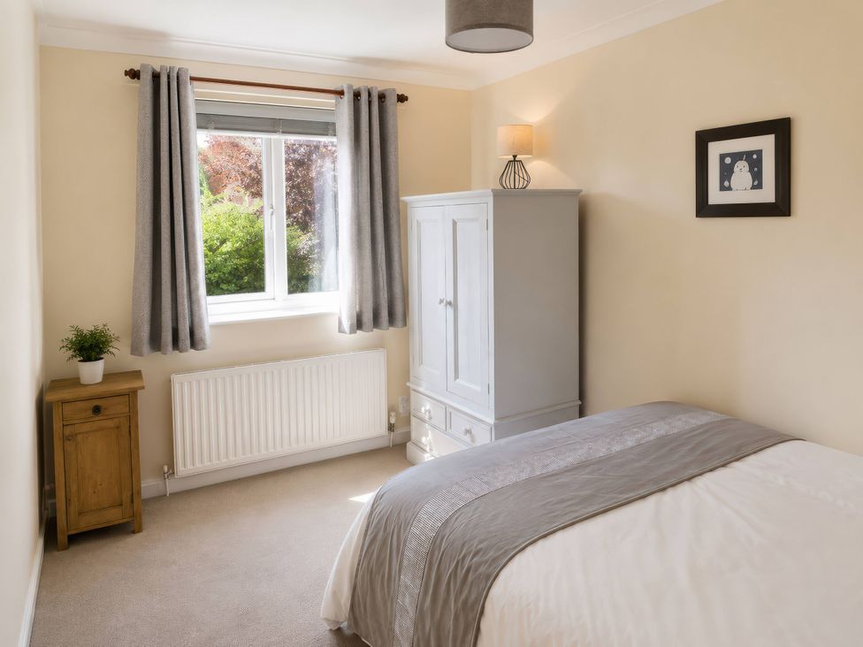 A bedroom with a bed and wardrobe at Beckside Cottage in Hebden Bridge