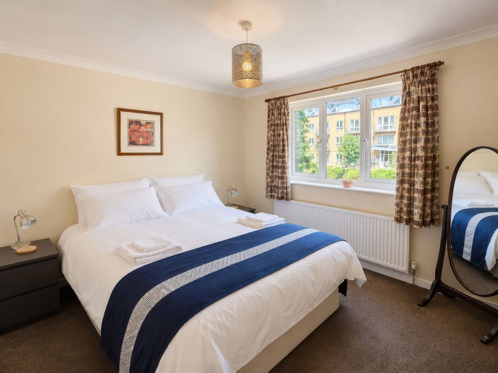 A bedroom with a bed and window at Beckside Cottage in Hebden Bridge
