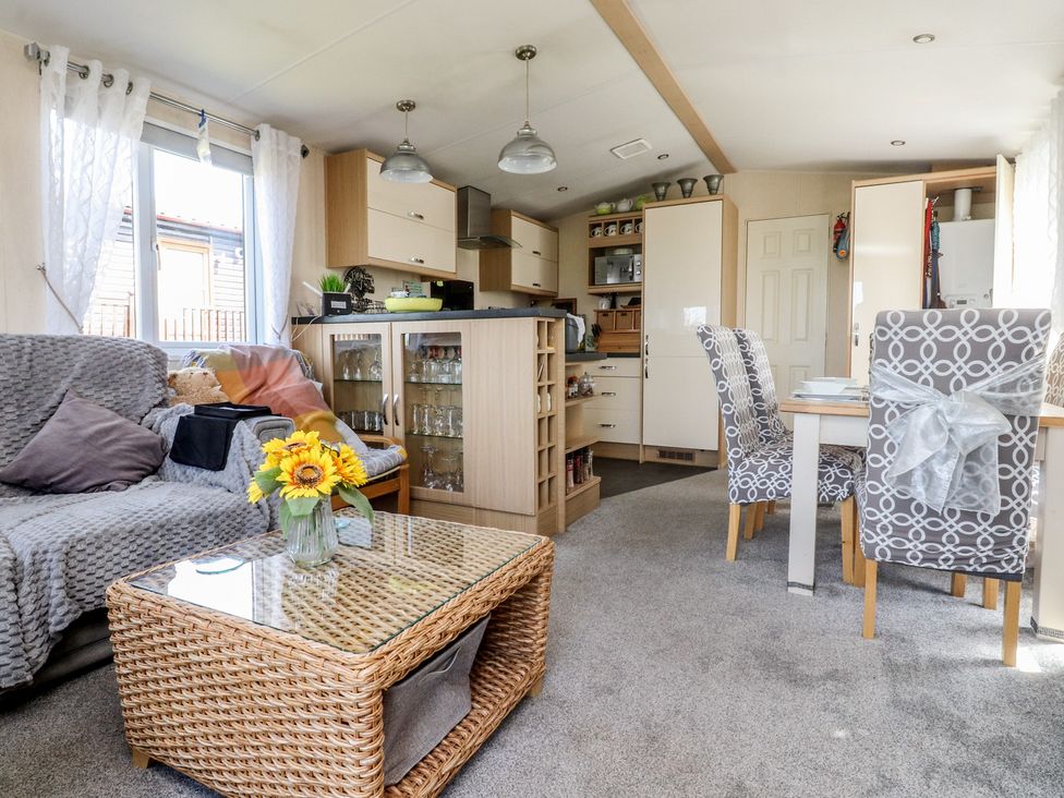 A living room with a couch, table and chairs at 33 Pendle View in Clitheroe