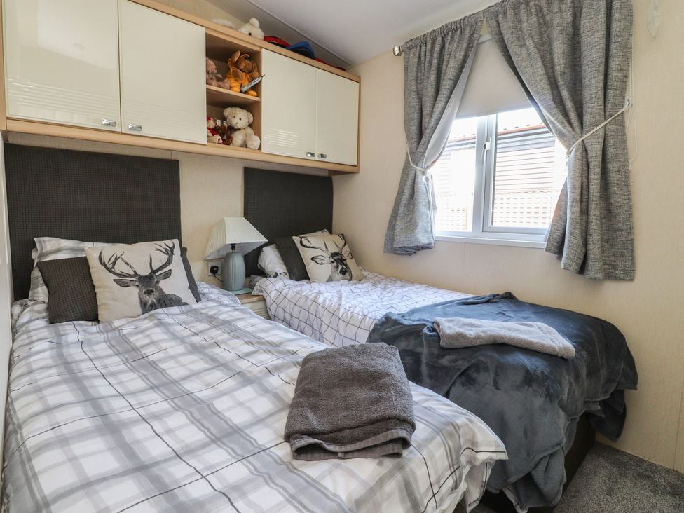 A bedroom with two beds and a window at 33 Pendle View in Clitheroe