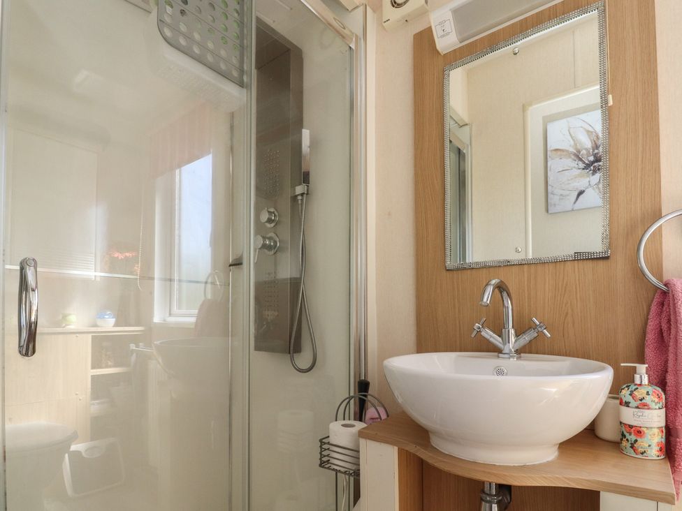 A bathroom with a shower and sink at 33 Pendle View Clitheroe