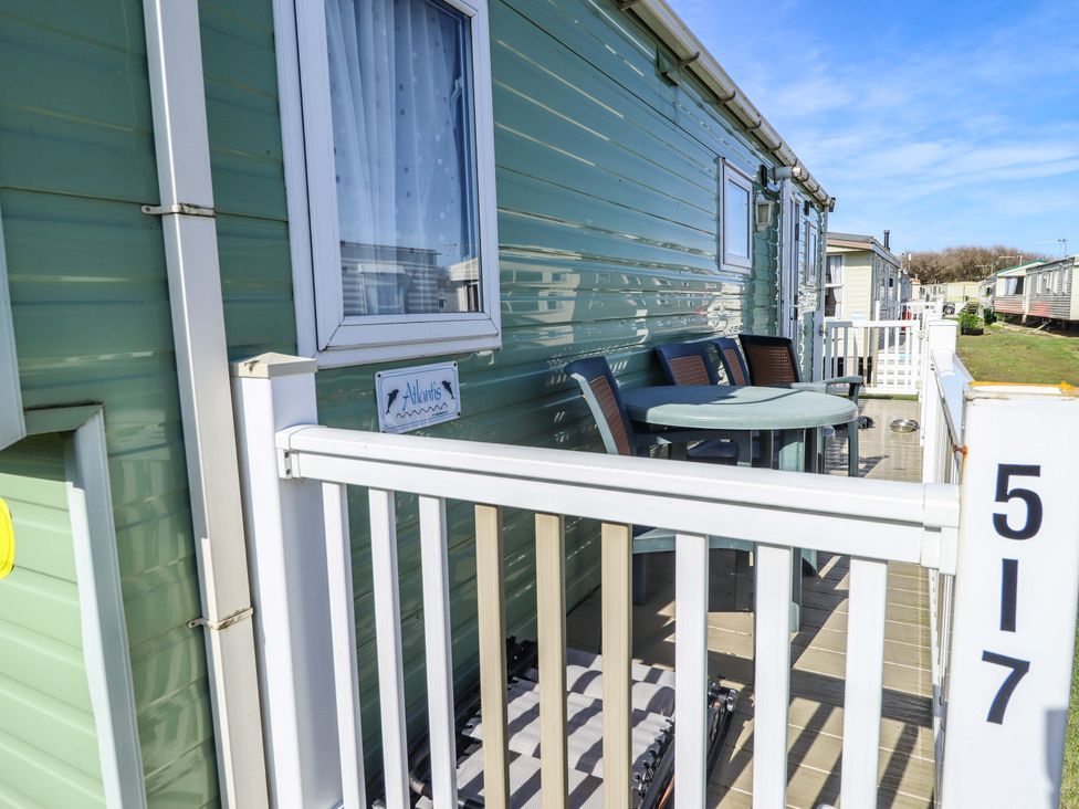 A caravan with a table and chairs on the deck at 517 - Promenade Caravan Site in Skegness