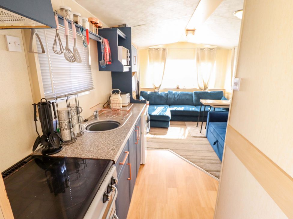 A kitchen with a countertop and living area in 517 - Promenade Caravan Site Skegness