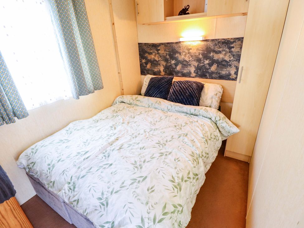 A bedroom with a bed and wardrobe at 517 - Promenade Caravan Site, Skegness