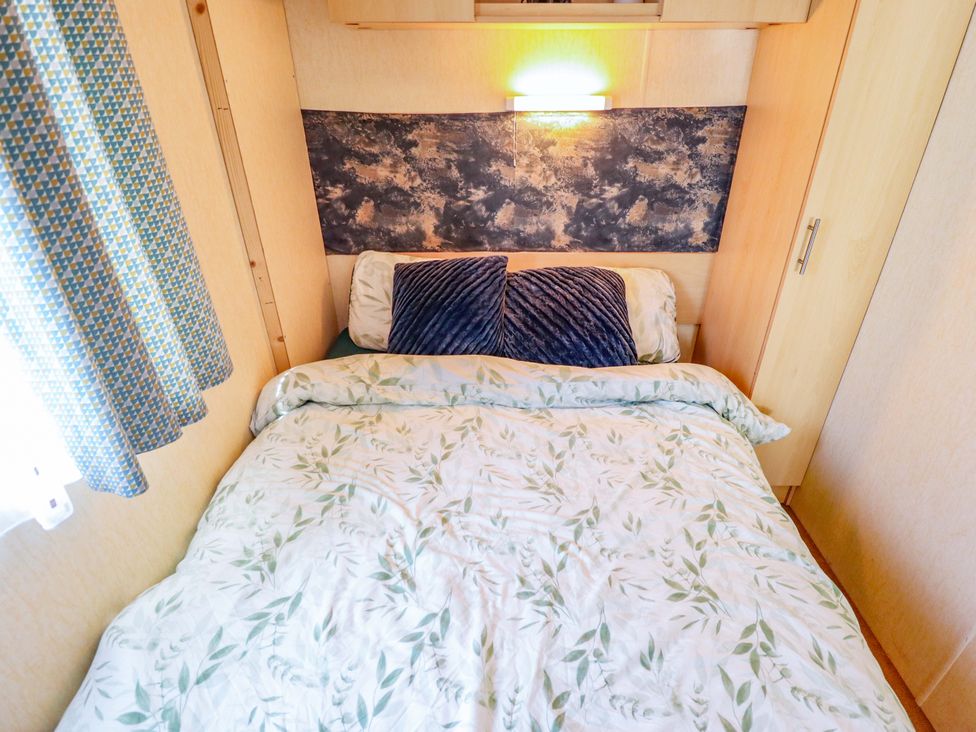 A bedroom with a bed and pillows at 517 - Promenade Caravan Site in Skegness
