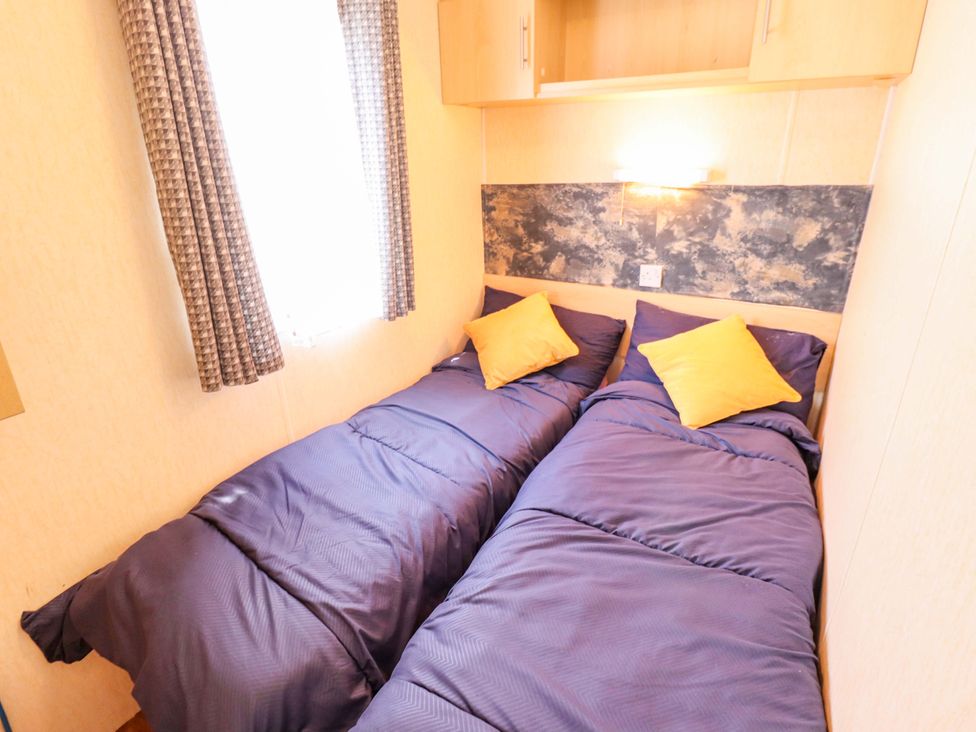 A bedroom with two single beds and a window at 517 - Promenade Caravan Site, Skegness