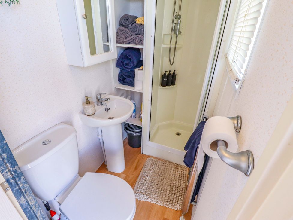 A bathroom with a shower, sink, and toilet at 517 - Promenade Caravan Site in Skegness