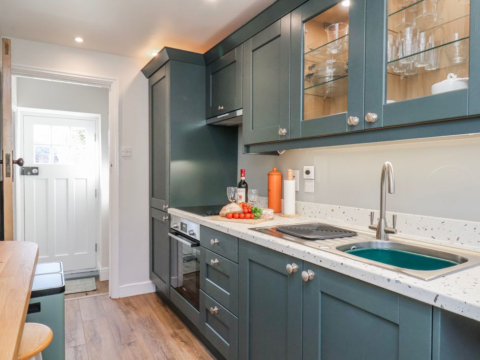 A kitchen with a sink and cabinets at Holly Cottage in Whitby