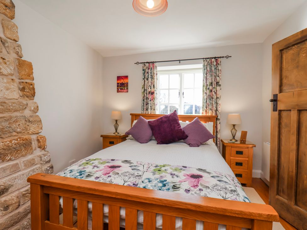 A bedroom with a bed and bedside table at Holly Cottage in Whitby