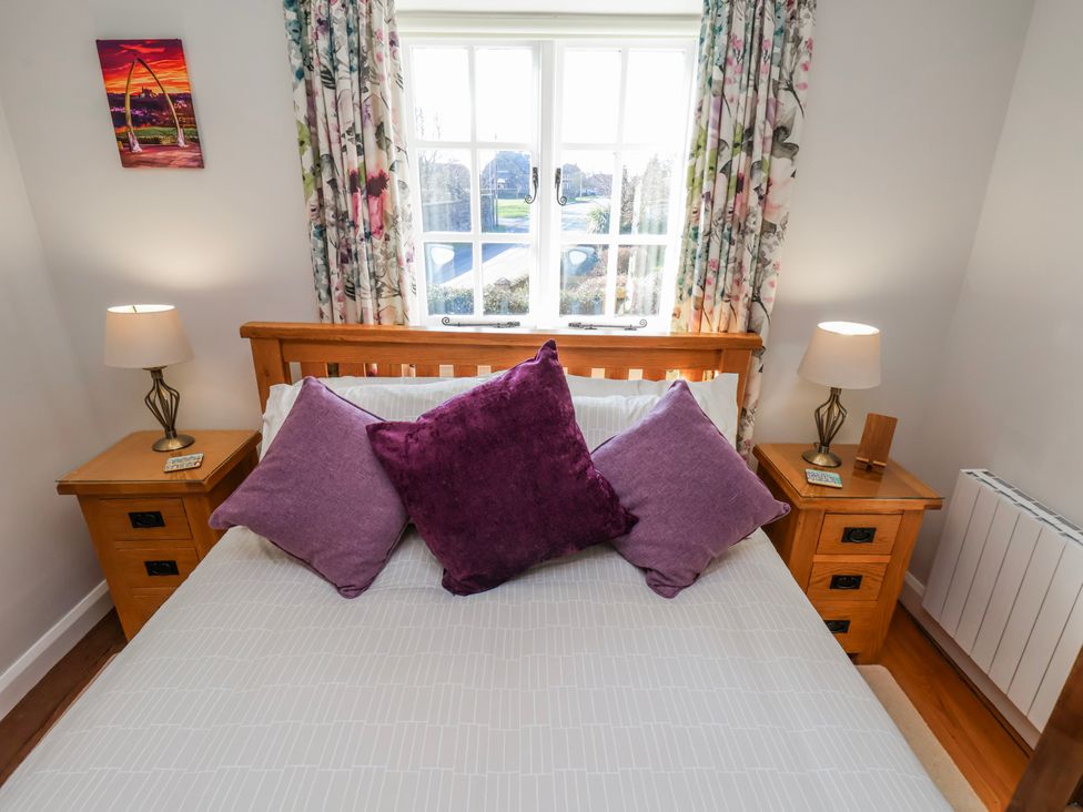 A bedroom with a bed and bedside tables at Holly Cottage in Whitby