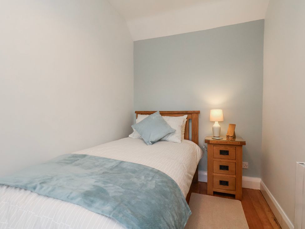 A bedroom with a single bed and nightstand at Holly Cottage Whitby