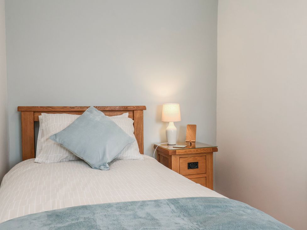 A bedroom with a bed and a nightstand at Holly Cottage in Whitby