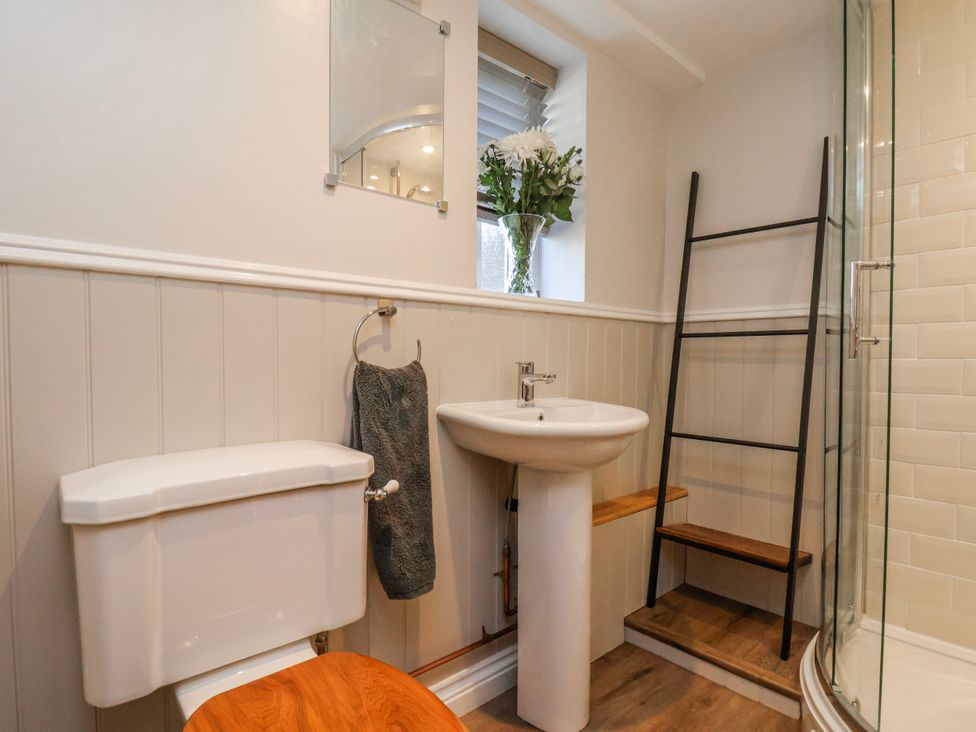 A bathroom with a toilet, sink, and shower at Holly Cottage in Whitby