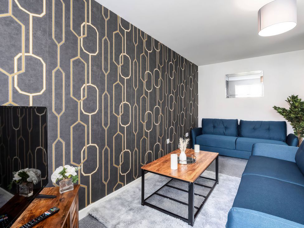 A living room with a blue sofa and wooden coffee table at 59 Eagle Drive in Grimsby