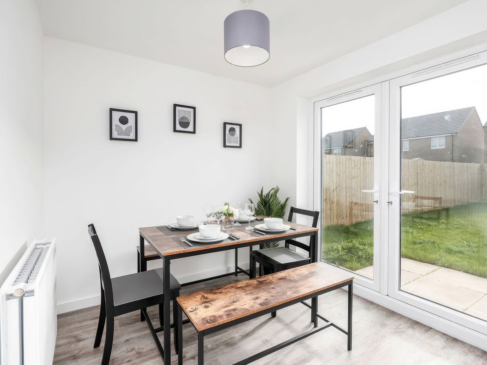 A dining room with a table and chairs at 59 Eagle Drive in Grimsby