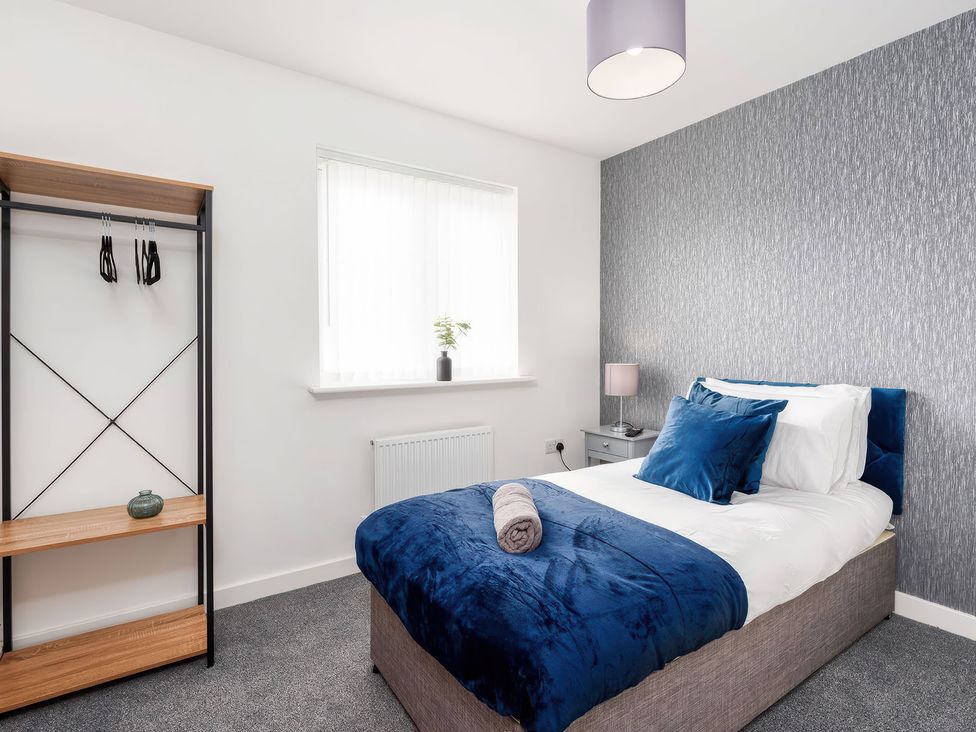 A bedroom with a bed and a nightstand at 59 Eagle Drive in Grimsby