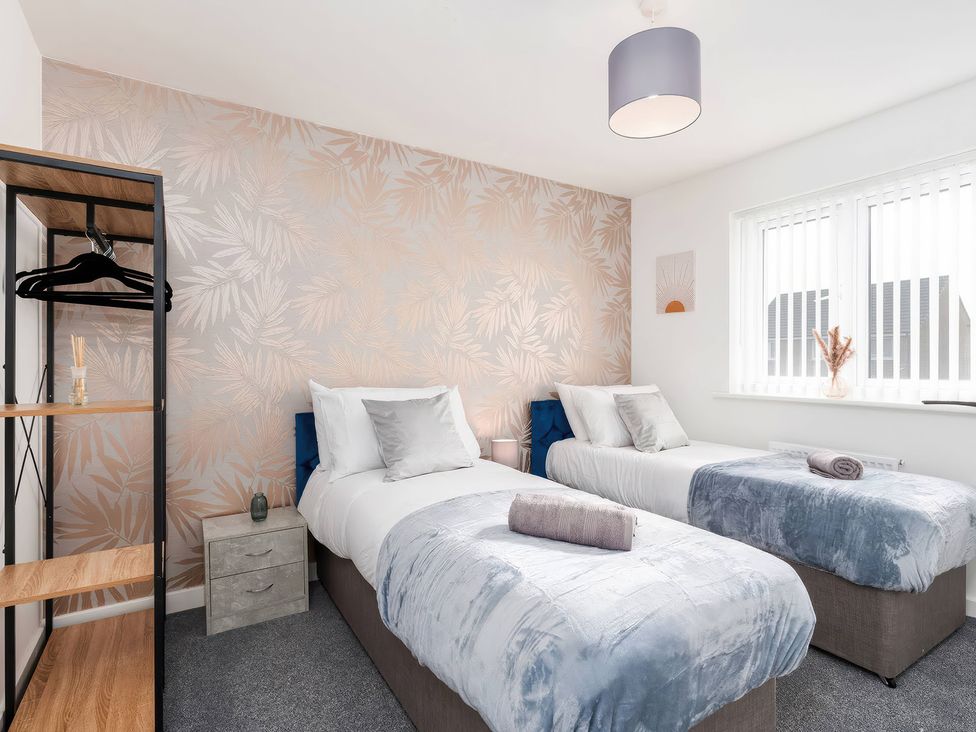 A bedroom with two beds and a clothes rack at 59 Eagle Drive in Grimsby