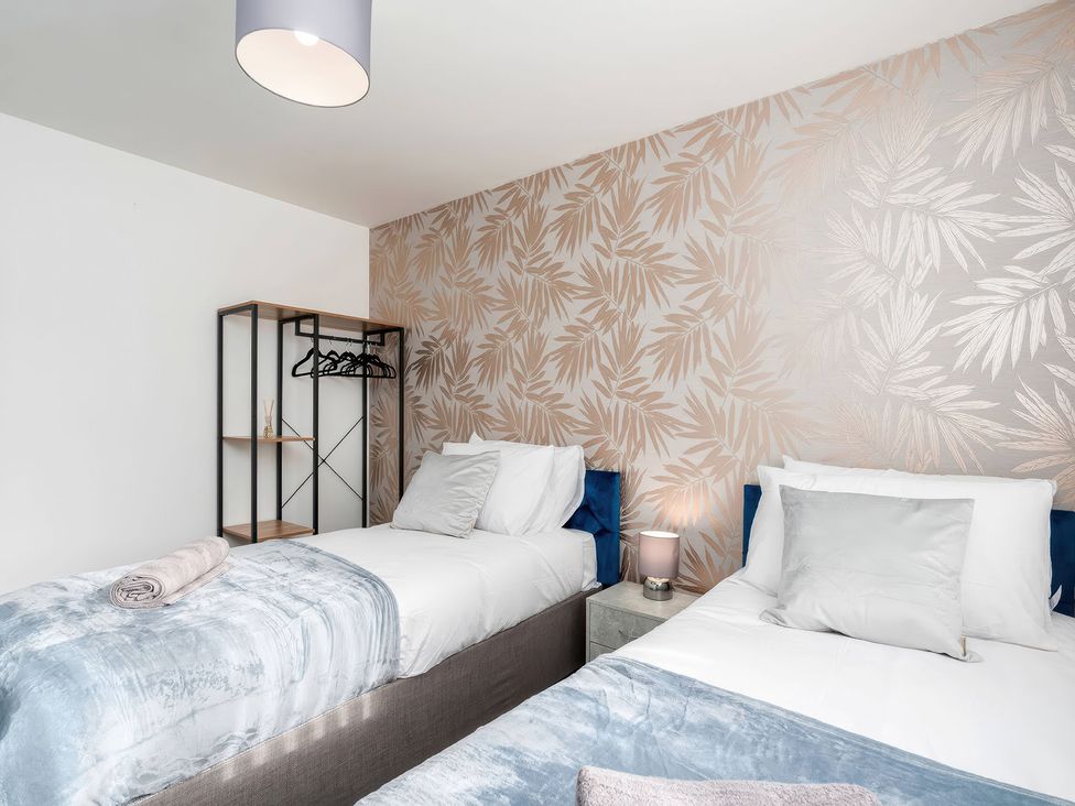 A bedroom with two beds and a shelf at 59 Eagle Drive in Grimsby