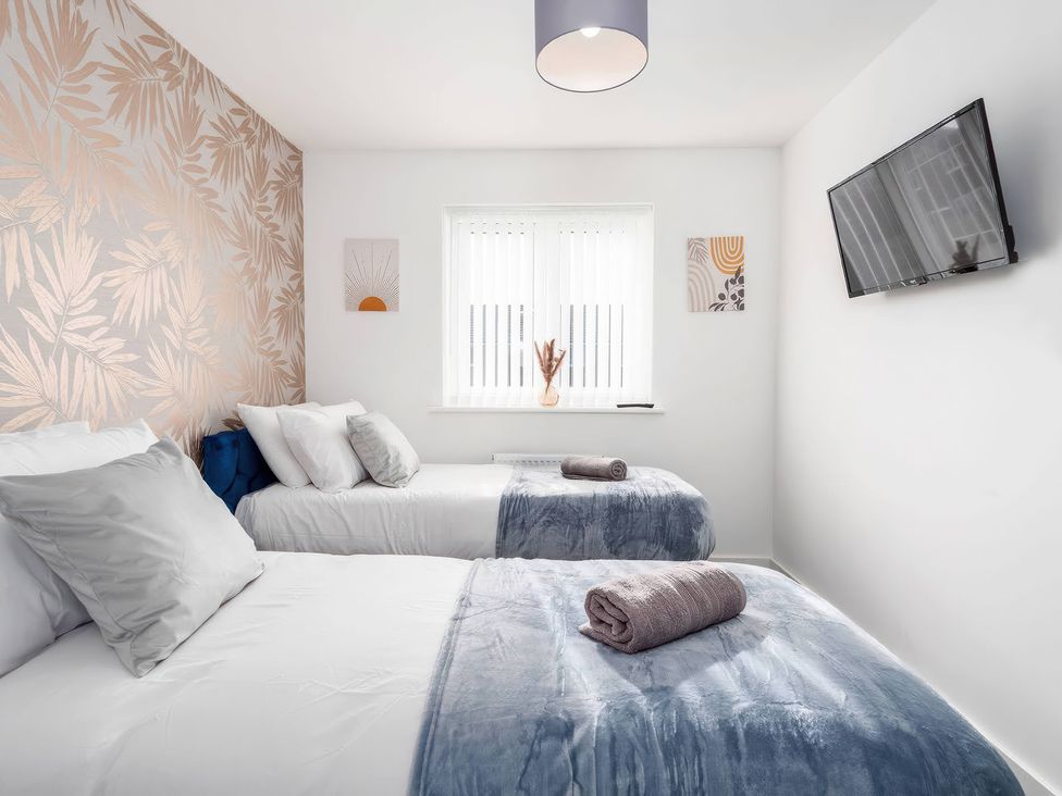 A bedroom with two beds and a TV at 59 Eagle Drive in Grimsby