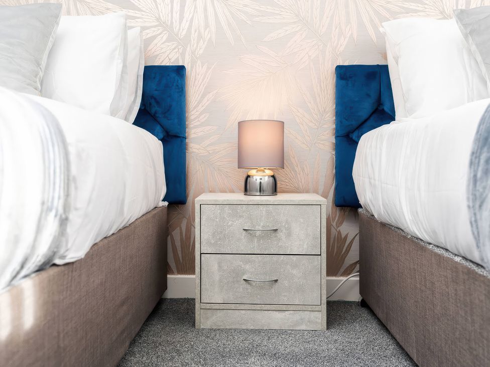 A bedroom with two beds and a nightstand at 59 Eagle Drive Grimsby