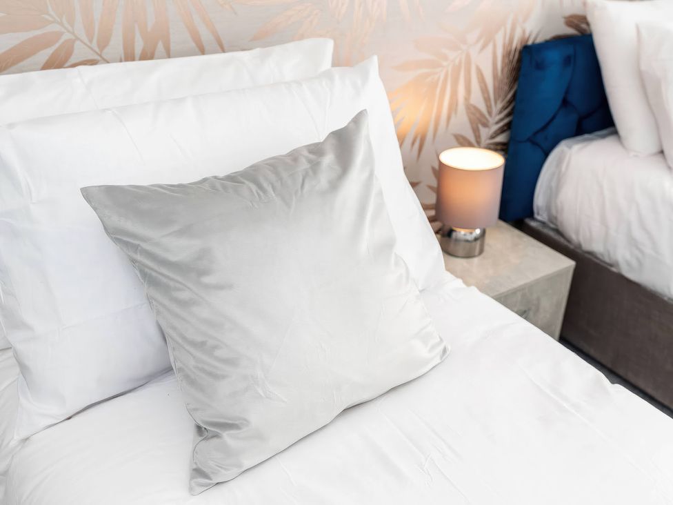 A bed with pillows and a lamp at 59 Eagle Drive in Grimsby