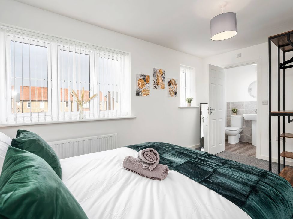 A bedroom with a bed and a view of a bathroom at 59 Eagle Drive Grimsby