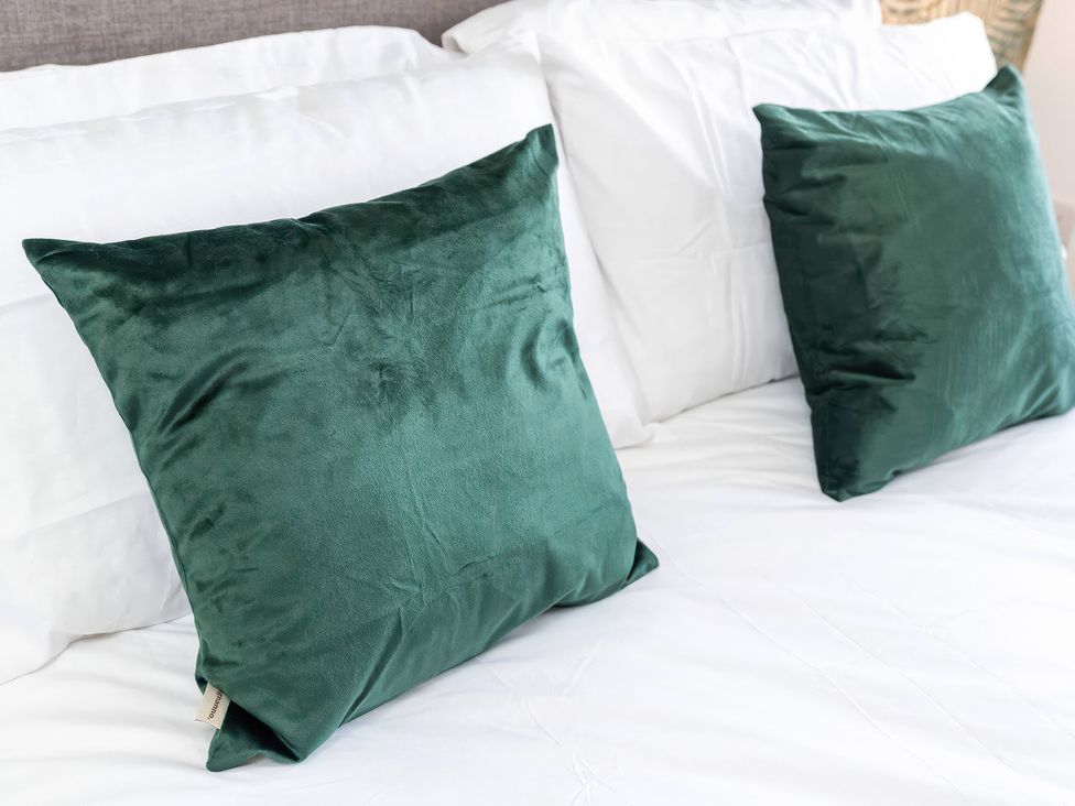 A bed with two green pillows at 59 Eagle Drive Grimsby