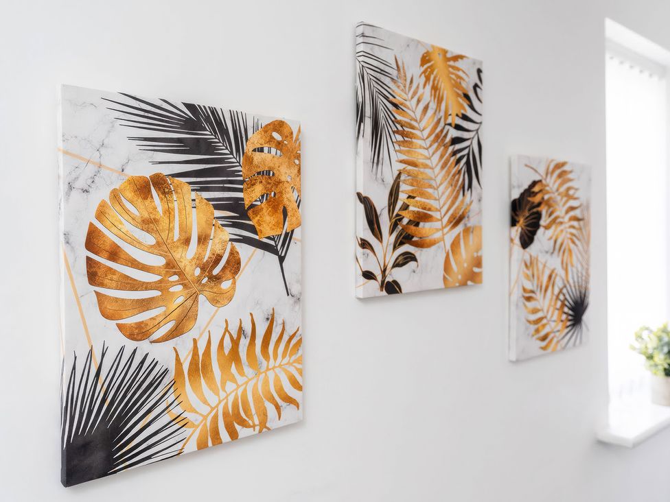 Three decorative panels with plant motifs on a wall