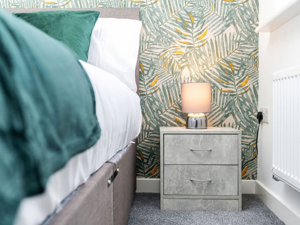 A bedroom with a bed and bedside table at 59 Eagle Drive Grimsby