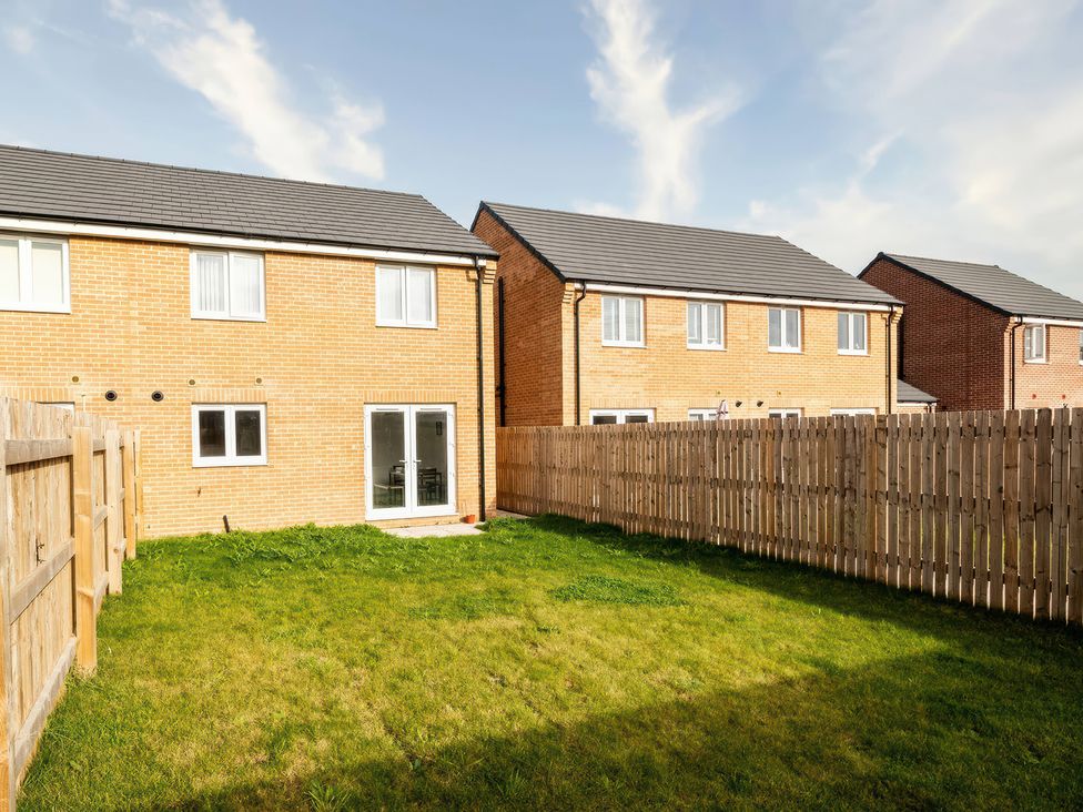 A garden with grass and houses at 59 Eagle Drive in Grimsby