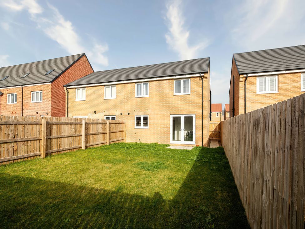 A backyard with grass and a fence at 59 Eagle Drive in Grimsby