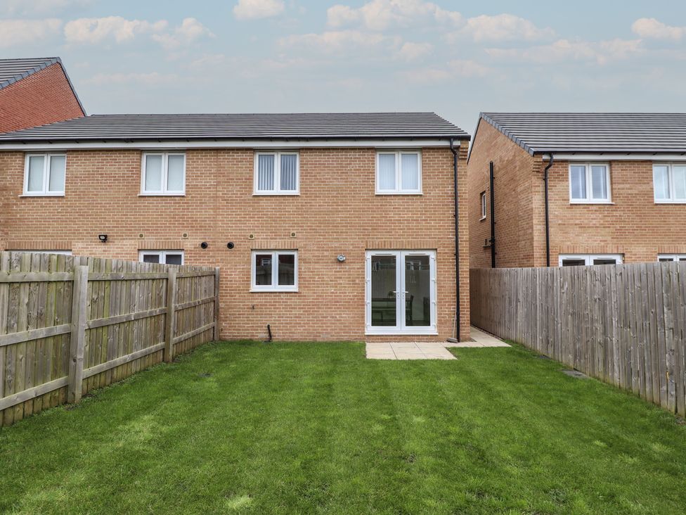 The rear view of a house with a garden and patio at 59 Eagle Drive New Waltham near Humberston, Lincolnshire