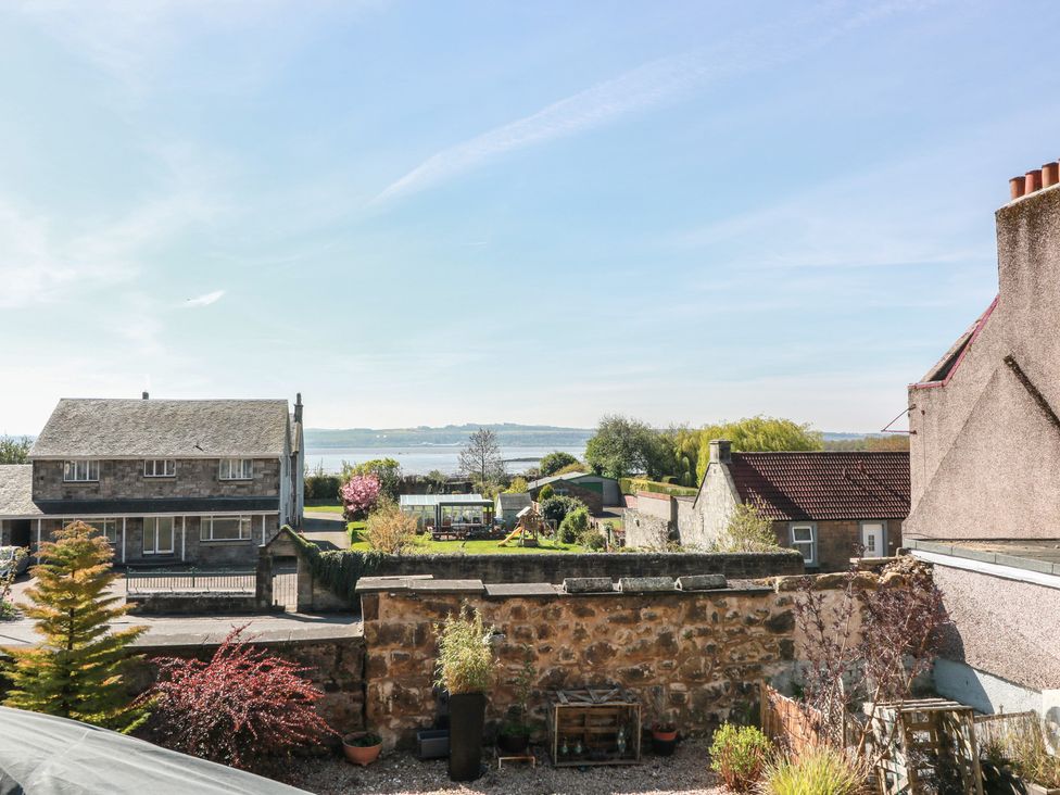 A view of houses and gardens near water at Crown Cottage Newmills near Cairneyhill