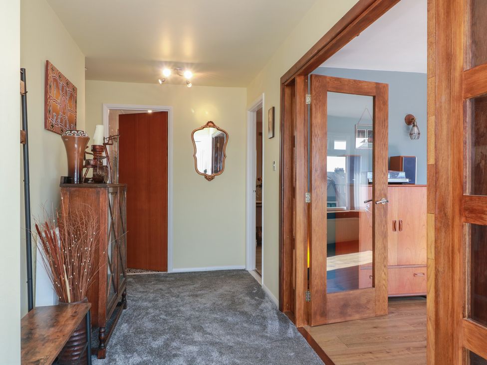 A hallway with a mirror and cabinet at Crown Cottage in Newmills near Cairneyhill