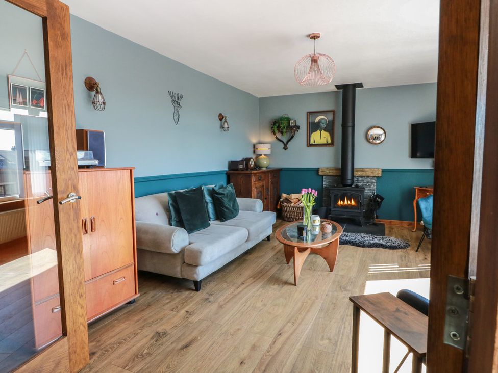 A living room with a fireplace and sofa at Crown Cottage in Newmills near Cairneyhill
